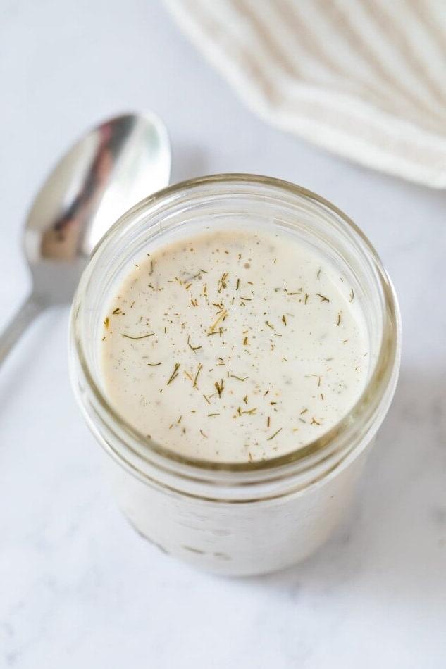 Βίγκαν Ραντς Σάλτσα 2 Βάζο Mason με βίγκαν σάλτσα ranch. Ένα κουτάλι βρίσκεται δίπλα.