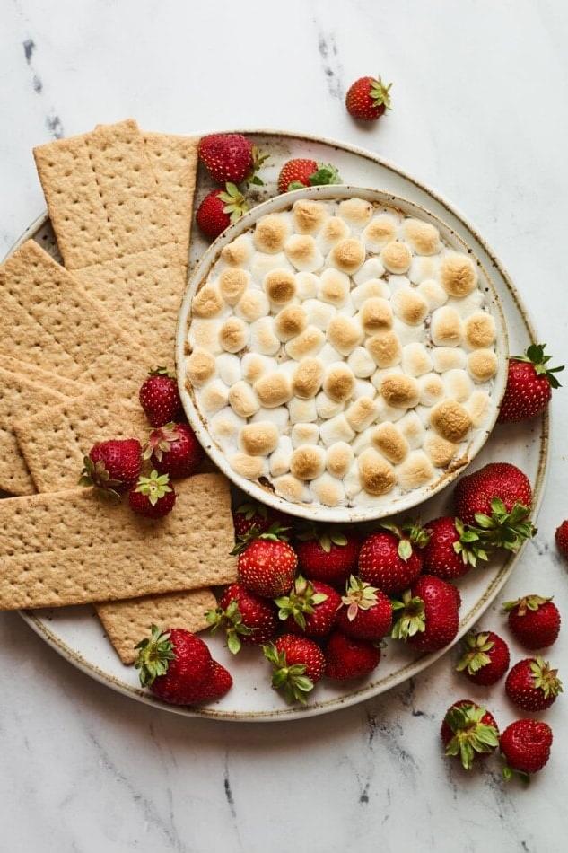 Υγιεινό Σμορς Ντιπ 2 S'mores dip σερβιρισμένο με φράουλες και μπισκότα γκράχαμ για βούτηγμα.