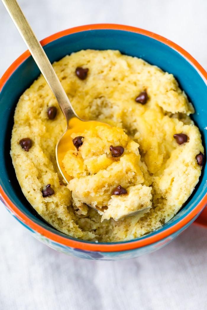 Καρυδόλευρο Κέικ Κούπας 2 Chocolate Chip Mug Cake in a mug with a spoon scooping a bite.