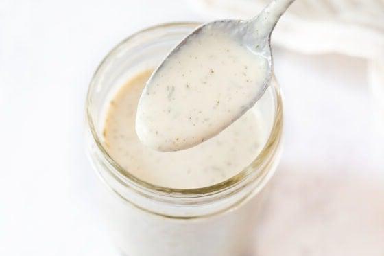 Κουτάλι με βίγκαν σάλτσα ranch από ένα βάζο Mason.