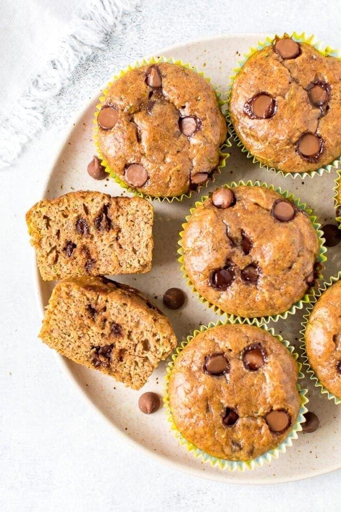 Μάφινς κολοκυθιού χωρίς αλεύρι 3 Πλάκα με muffins. Ένα muffin είναι κομμένο στη μέση και φαίνονται οι σταγόνες σοκολάτας.