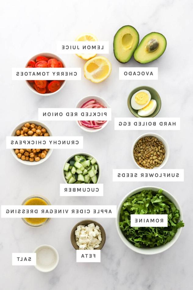 Μπολ Πουρές Αβοκάντο 3 Ingredients measured out to make Mashed Avocado Bowl: avocado, lemon juice, cherry tomatoes, hard boiled egg, pickled red onion, crunchy chickpeas, sunflower seeds, cucumber, apple cider vinegar dressing, romaine, feta and salt.