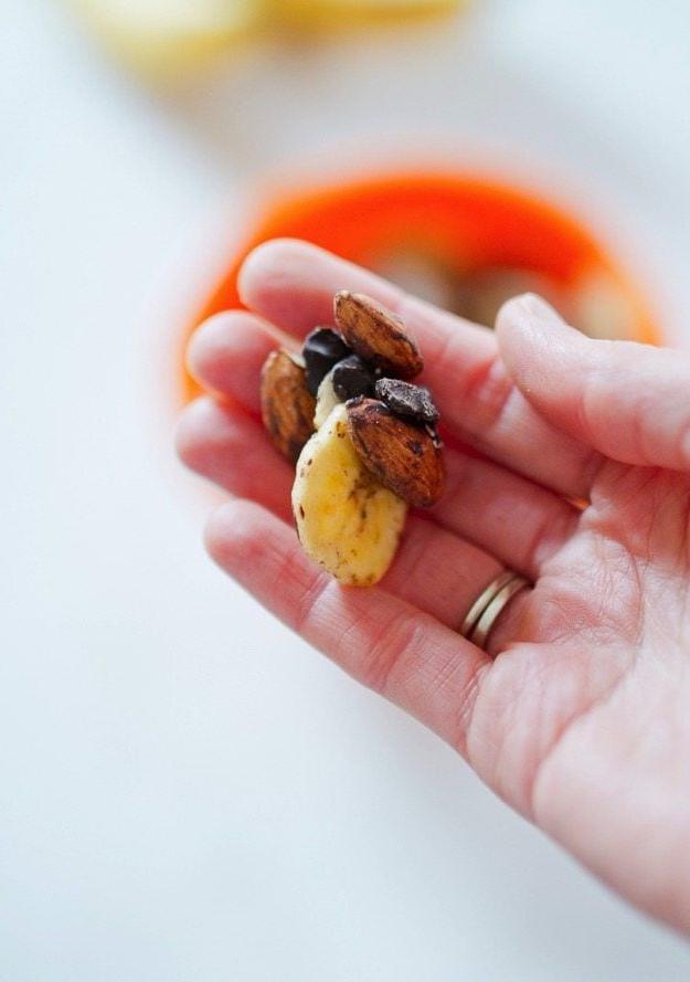 PIN THIS --> Chunky Monkey Trail Mix Χέρι που κρατάει trail mix με τσιπς μπανάνας, σοκολάτα και αμύγδαλα.