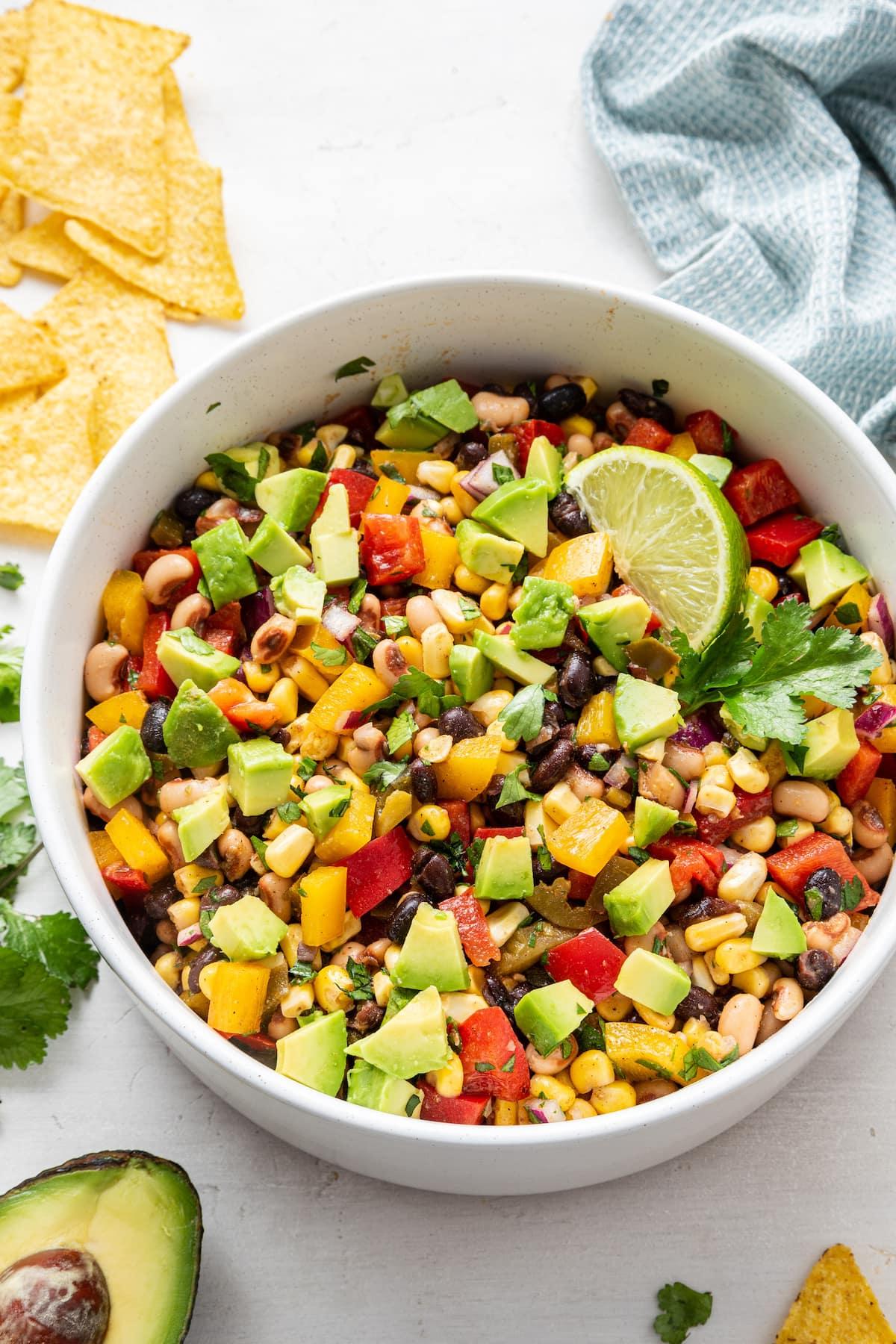Καουμπόι Χαβιάρι 9 Ένα μπολ με σαλάτα Cowboy Caviar με κομμένο αβοκάντο και μια φέτα λάιμ.