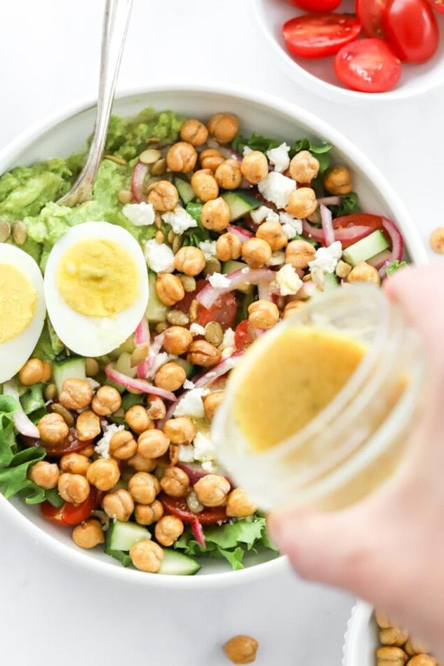 Μπολ Πουρές Αβοκάντο 6 Pouring dressing over top of a mashed avocado bowl.