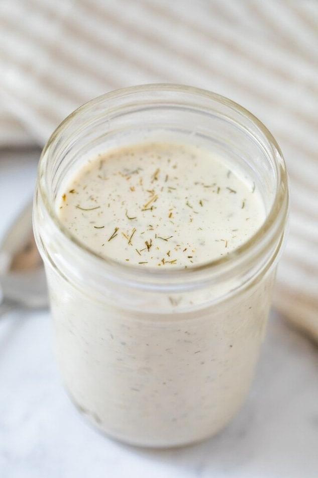 Βίγκαν Ραντς Σάλτσα 7 Βάζο Mason με βίγκαν σάλτσα ranch. Ένα κουτάλι βρίσκεται δίπλα.