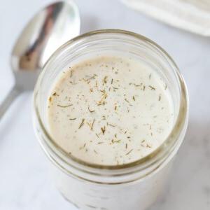 Βίγκαν Ραντς Σάλτσα 8 Βάζο Mason με βίγκαν σάλτσα ranch. Ένα κουτάλι βρίσκεται δίπλα.