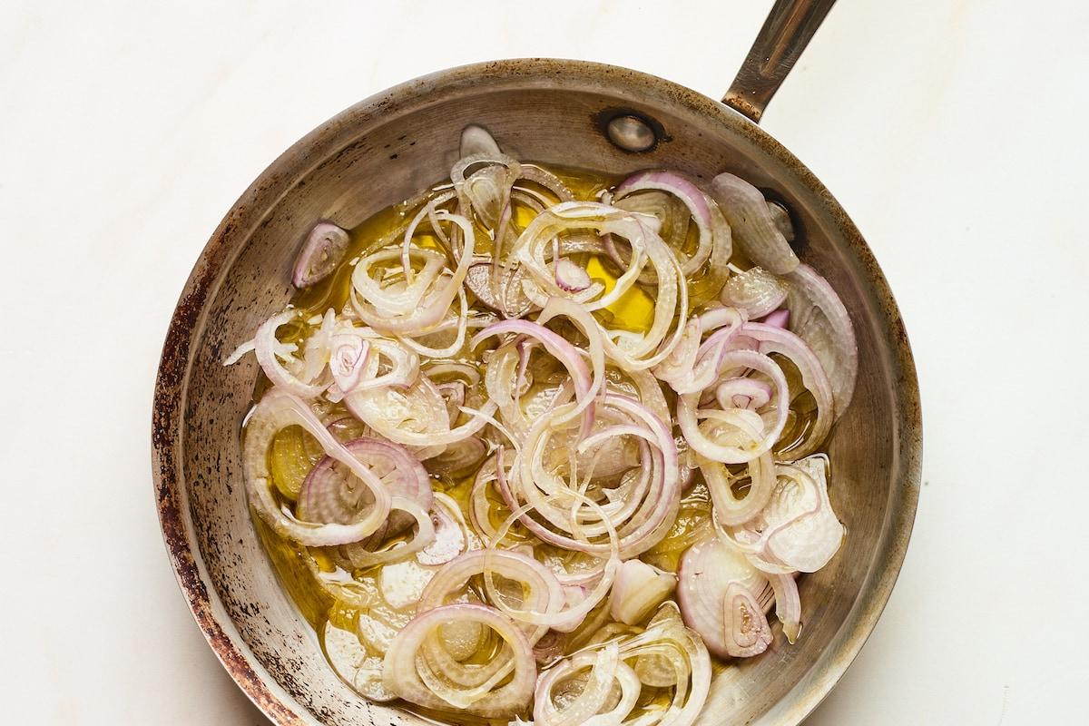 Φασολάκια Σαλάτα 8 Sliced shallots in oil in a frying pan.