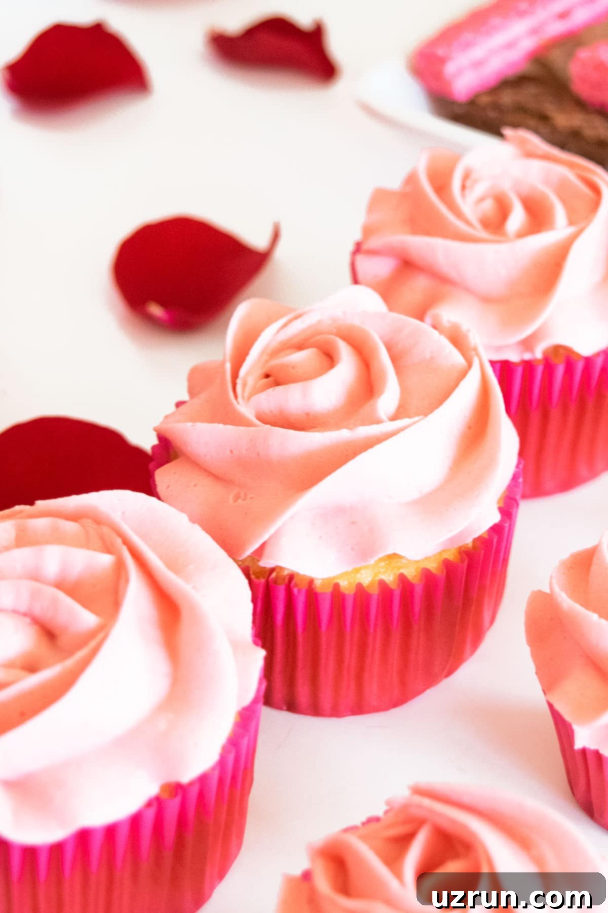 Delicious Food and Romantic Decor for Your Valentine's Day Party 5 Pink Rose Cupcakes on White Table.