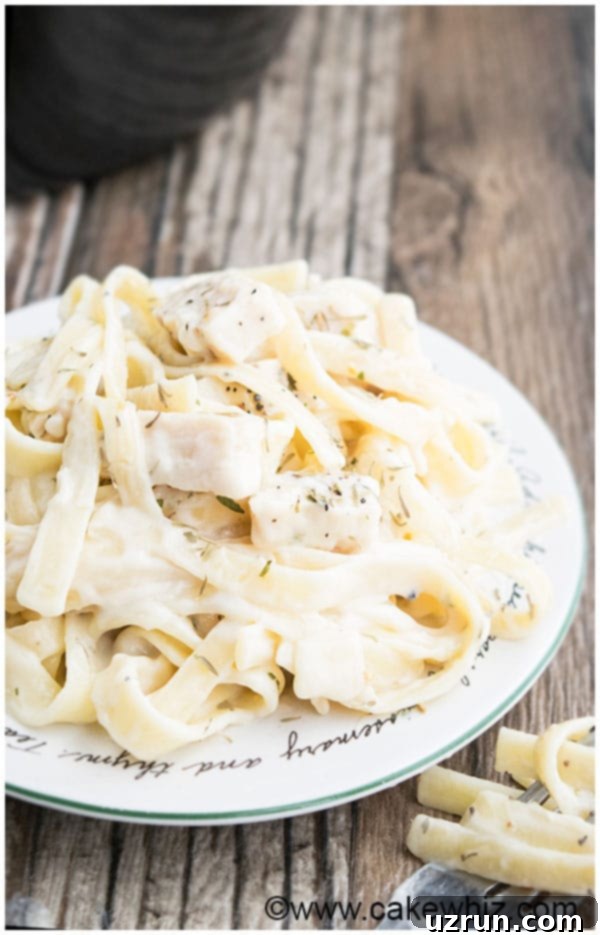 Slow Cooker Easy Chicken Alfredo served on a plate with fresh basil