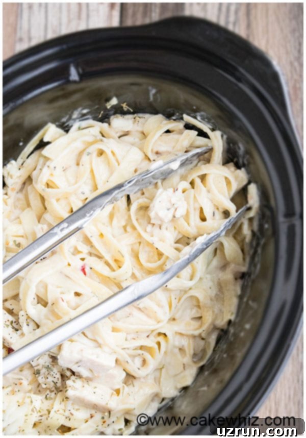 Close-up of Slow Cooker Easy Chicken Alfredo with pasta and garnish