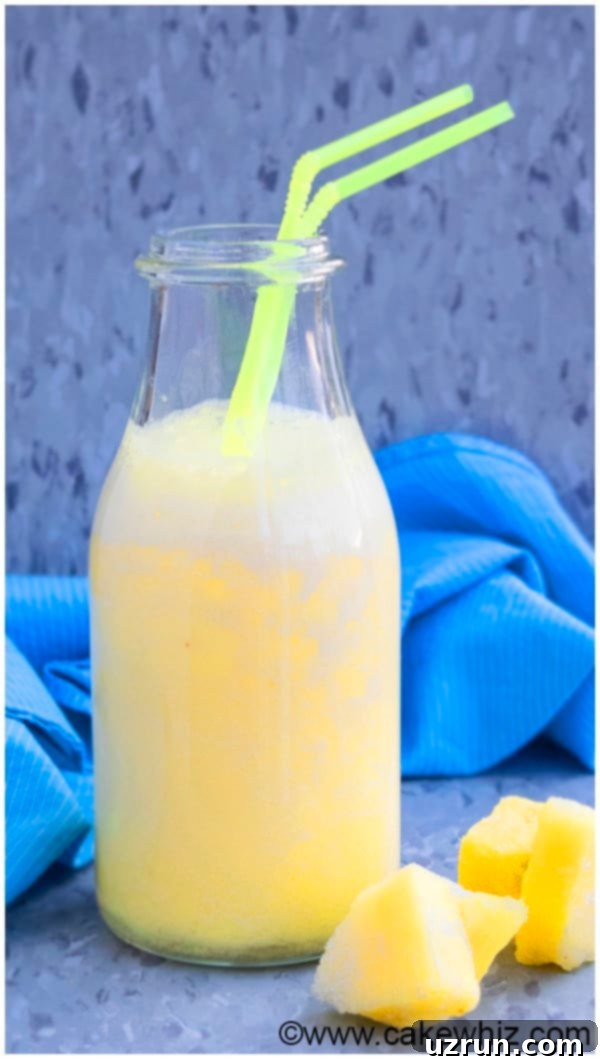 Easy Tropical Pineapple Smoothie in Glass Bottle With Straw. 