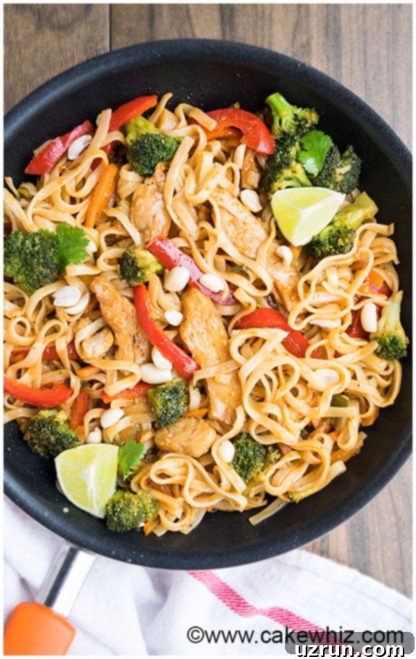 Close-up of a serving of Chicken Pad Thai with lime and peanuts.