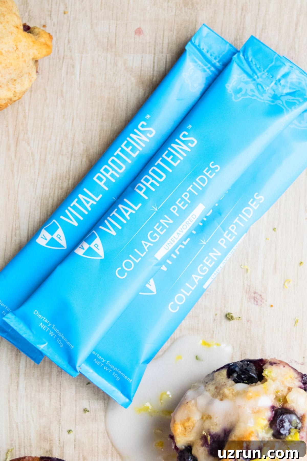 Glazed Lemon Blueberry Muffins 4 VP Collagen Peptides Packets on Light Brown Background.