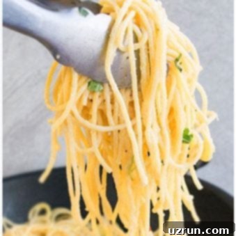 Zesty One-Pot Lemon Garlic Pasta 5 Tongs Full of Easy Lemon Garlic Pasta Over a Large Nonstick Pot.