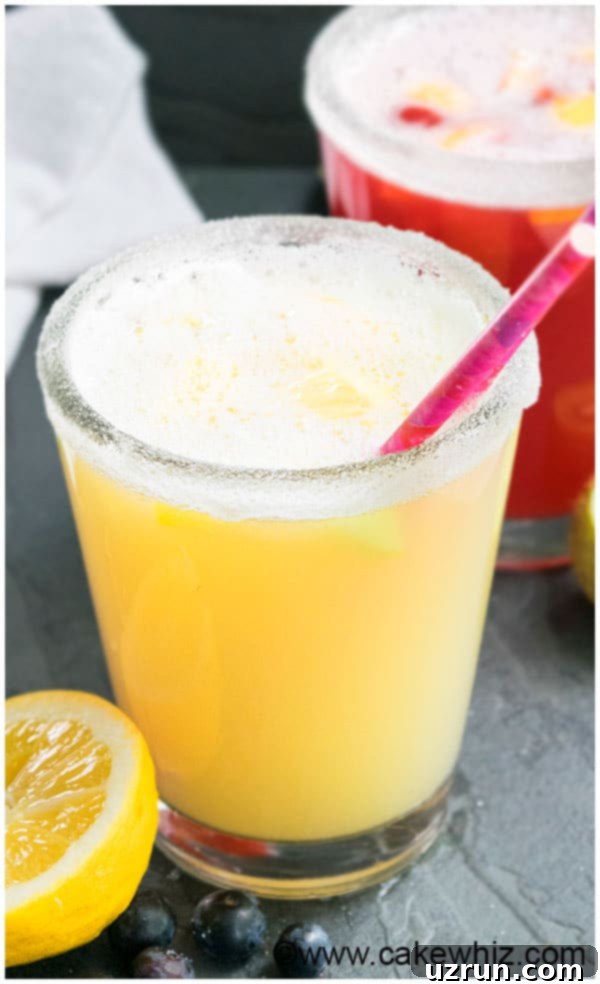 Old Fashioned Sparkling Lemonade Recipe served in a clear glass pitcher with lemon slices and mint