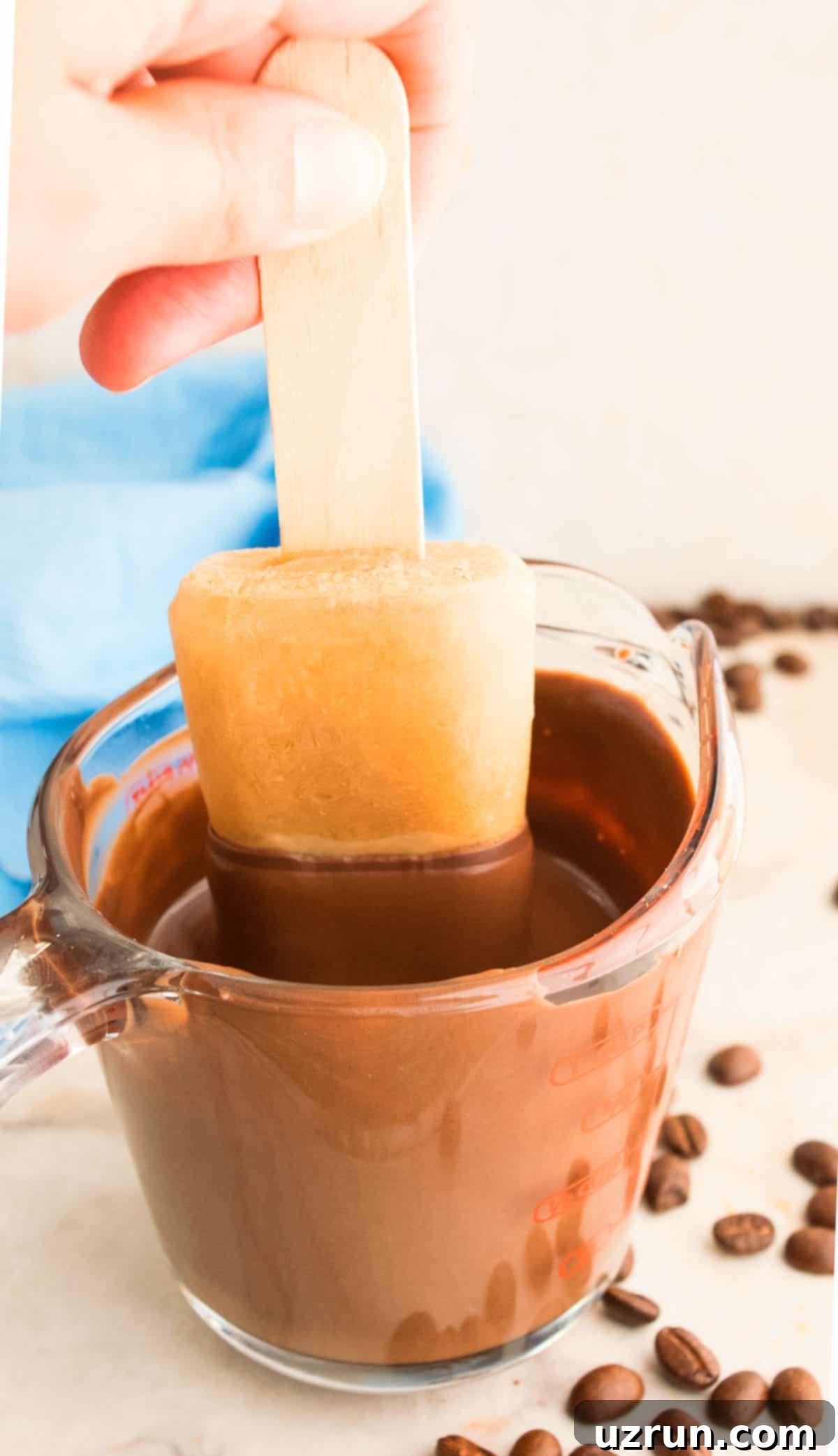 Iced Coffee Pops 3 Action Shot of Frozen Popsicle Being Dipped in Cup of Melted Chocolate.