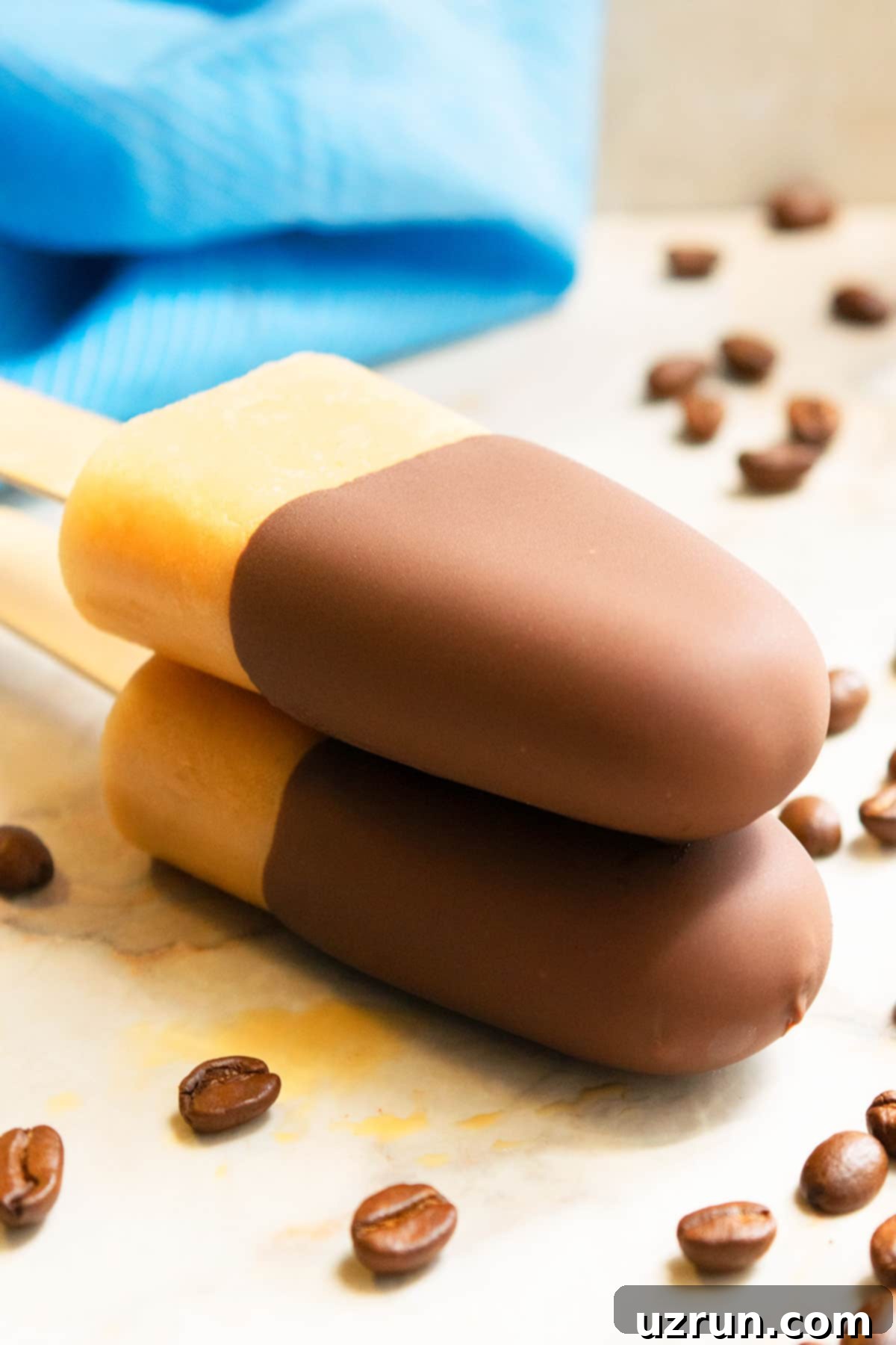 Iced Coffee Pops 4 Stack of Chocolate Dipped Mocha Popsicles on Marble Background.