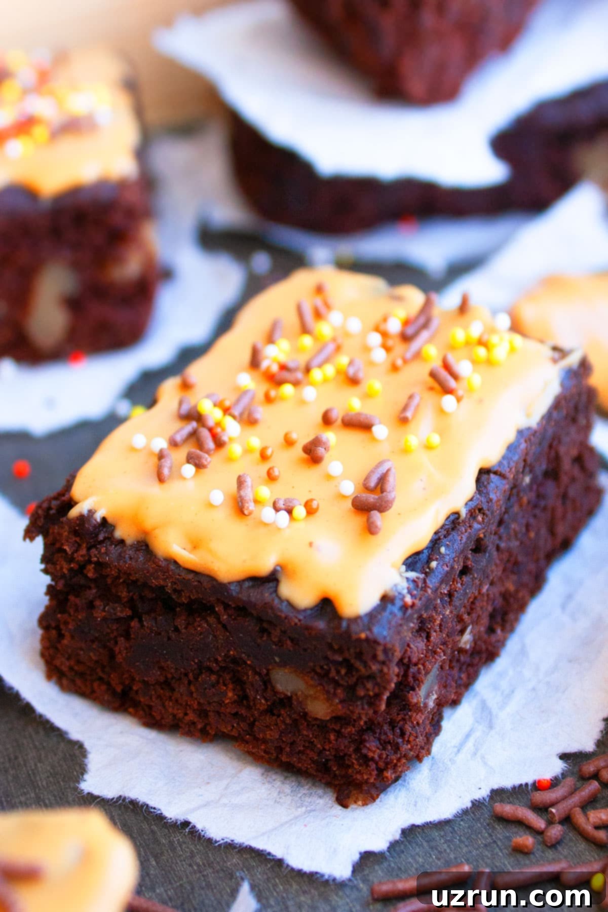 Mocha Espresso Brownies 3 Slice of Espresso Brownies With Glaze and Sprinkles on Sheet of Parchment Paper.