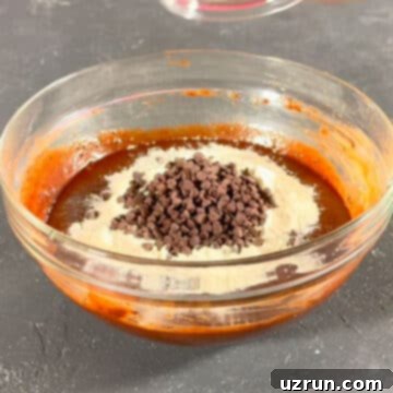 Mocha Espresso Brownies 8 Flour and chocolate chips adds to chocolate mixture in glass bowl.