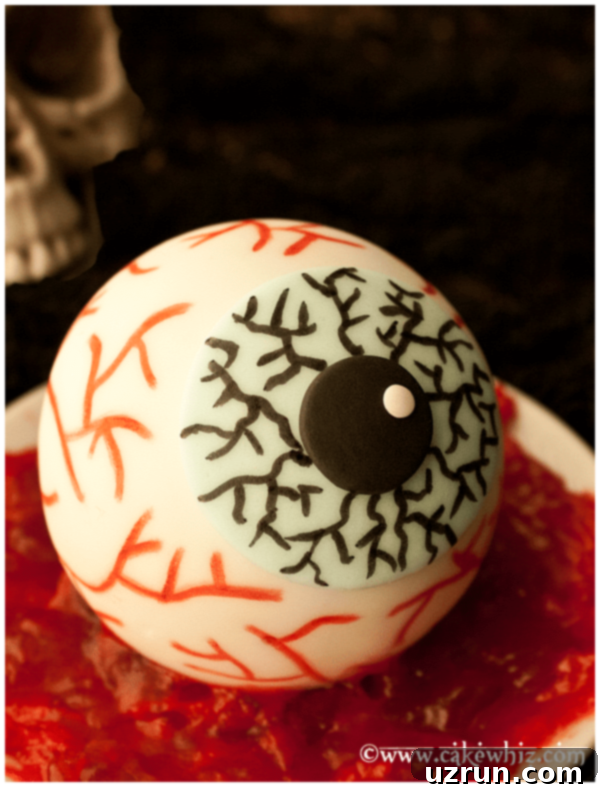 Creepy Eyeball Cake on Plate With Red Jam, decorated with realistic red veins