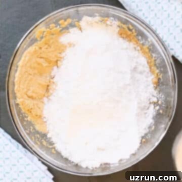 Easy Peanut Butter Blossoms with Hershey's Kisses 7 Dry ingredients added to wet ingredients in glass bowl.