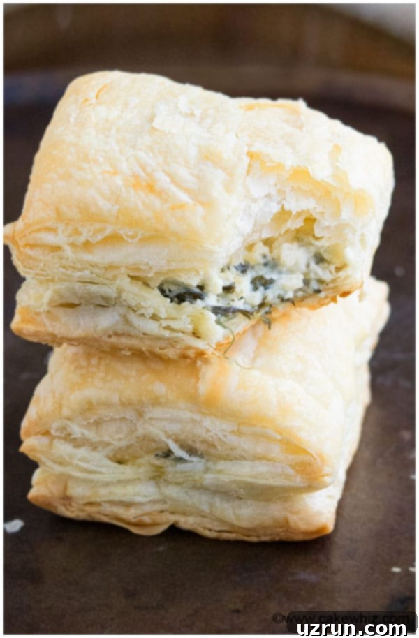 Irresistible Spinach and Feta Bites 4 Partially Eaten Vegetarian Puffs Appetizer With Cheese and Spinach on Dark Metal Tray.