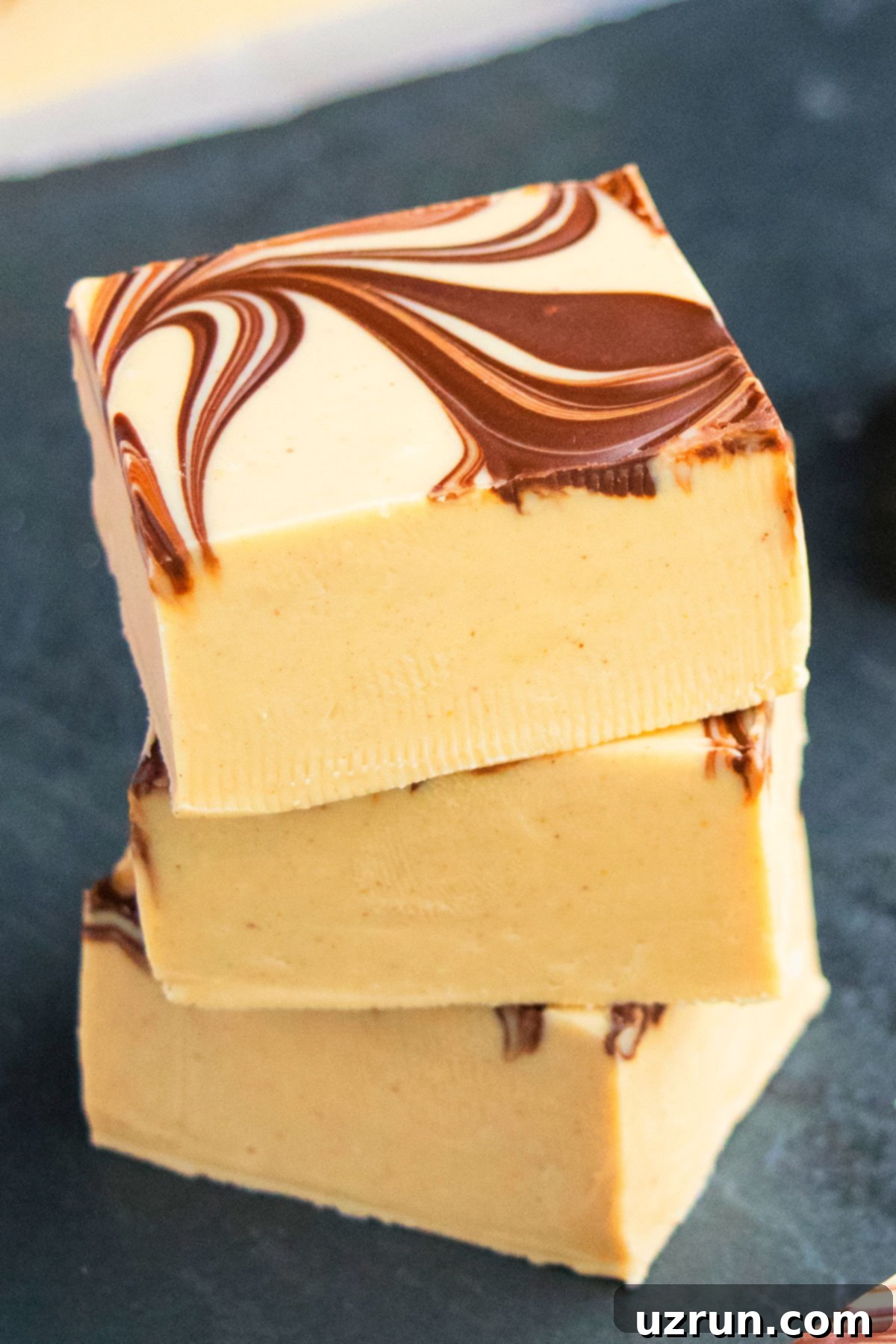 Stack of Easy Chocolate Peanut Butter Fudge on Dark Gray Background. 