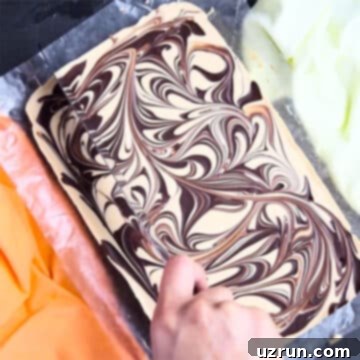 Chocolate Peanut Butter Swirl Fudge 9 Chilled fudge being sliced with sharp knife.