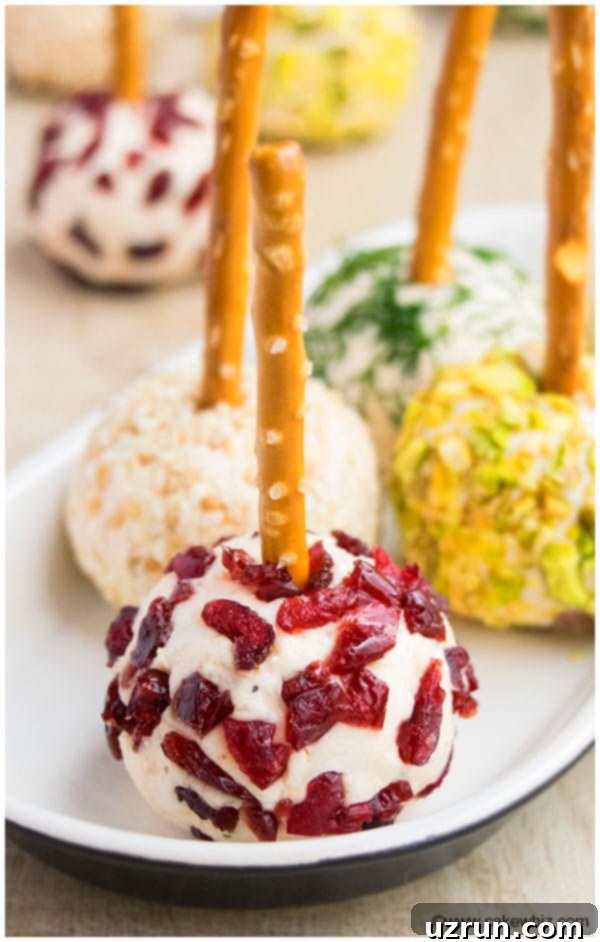 Mini Cheese Ball Appetizer With Pretzel Sticks on Small White Tray.