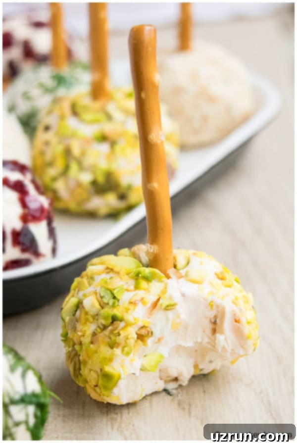 Partially Eaten Mini Cheese Ball Bites Covered in Chopped Pistachios.
