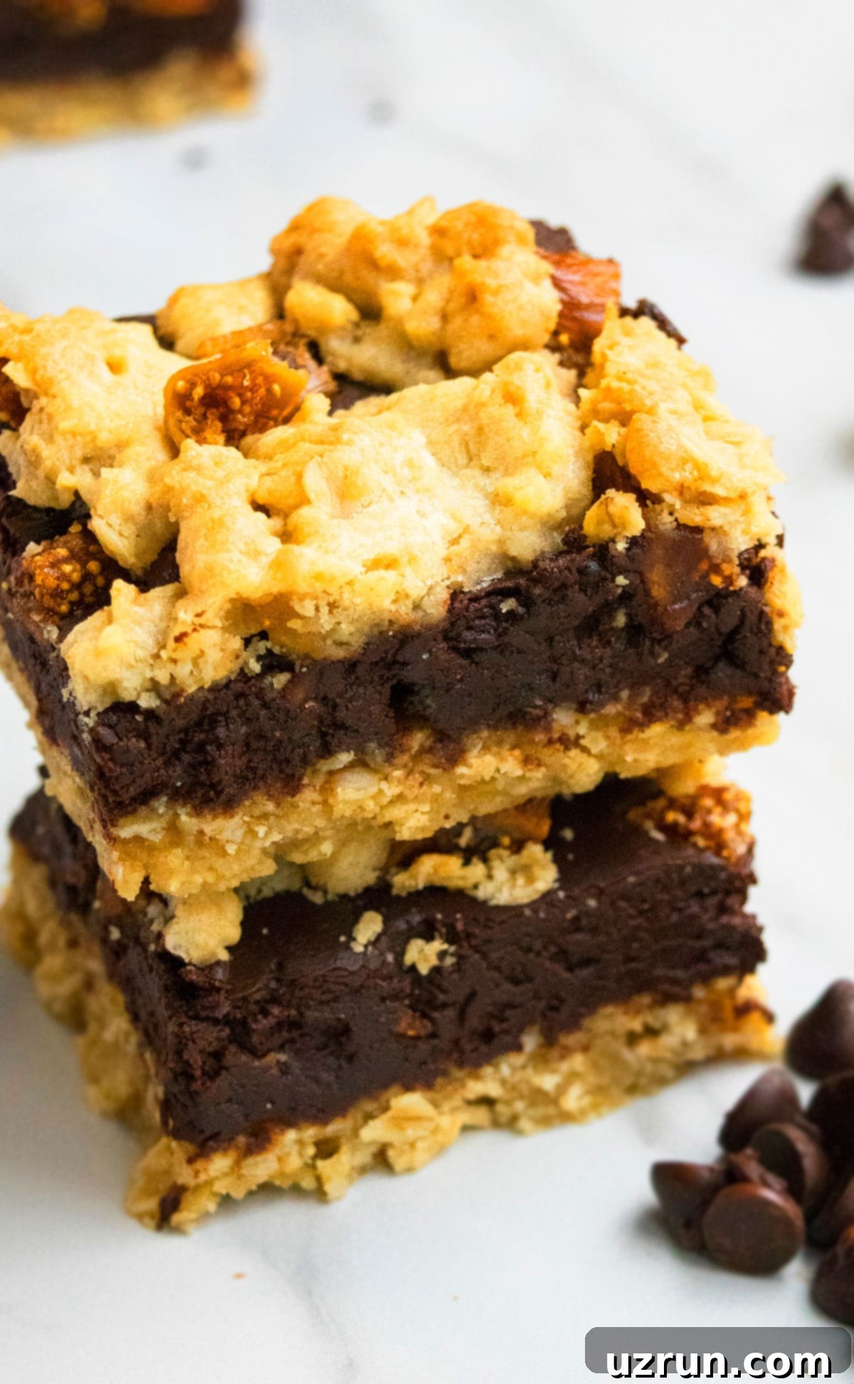 Stack of Easy Homemade Chocolate Oatmeal Bars on a Marble Background, showcasing the fudgy chocolate layer and crumbly oatmeal topping.