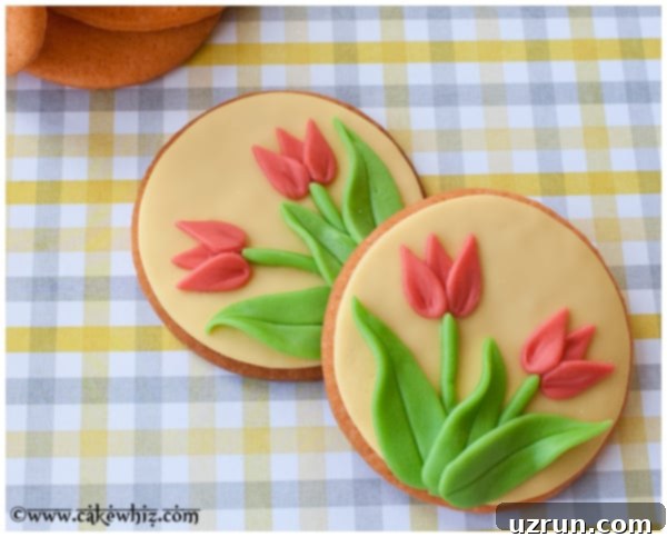 Simple Fondant Tulip Cookies 3 Decorated Sugar Cookies Overlapped On Each Other on Gingham Background, displaying a close-up of the delicate fondant tulip designs.