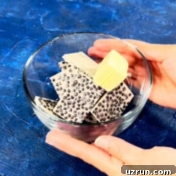 Five-Layer Chocolate Cookie Bars 10 Cookies and cream candy bar pieces and butter in glass bowl.