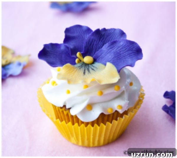 Easy Flower Cupcakes in Yellow Liners and Pink Background, adorned with vibrant fondant pansies