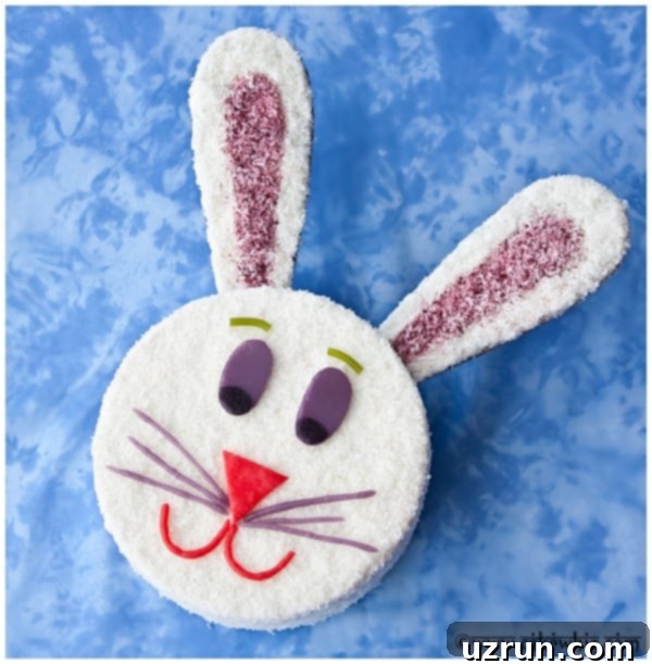 Easy Vintage Bunny Cake With Frosting and Coconut on Blue Background. An adorable, fluffy white bunny cake with pink ears and candy facial features, set against a cheerful blue backdrop, perfect for Easter.