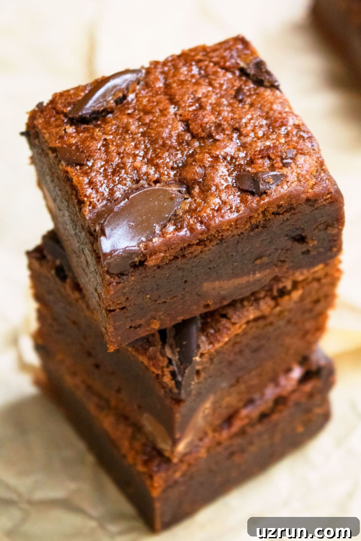 Stack of Fudgy Black Bean Brownies on Brown Parchment Paper.