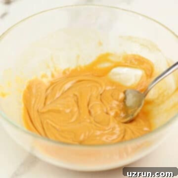 Effortless No Bake Granola Bars 5 Peanut butter and honey being heated and mixed together.