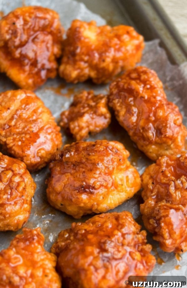 Spicy Honey Sriracha Chicken Bites on Sheet of Wax Paper. 