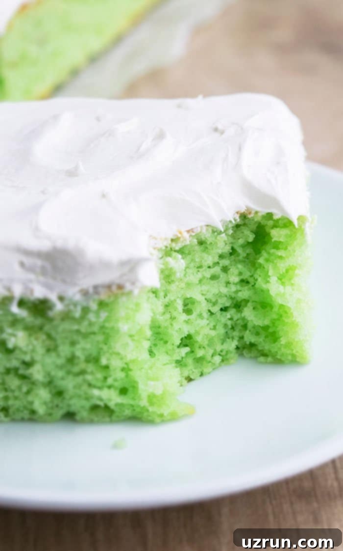 Effortless Pistachio Cake 3 Homemade Pistachio Pudding Cake With Spoonful Removed on White Plate, showing its moist green interior