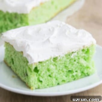 Effortless Pistachio Cake 6 Pistachio Cake with Cake Mix and Whipped Cream on White Dish.
