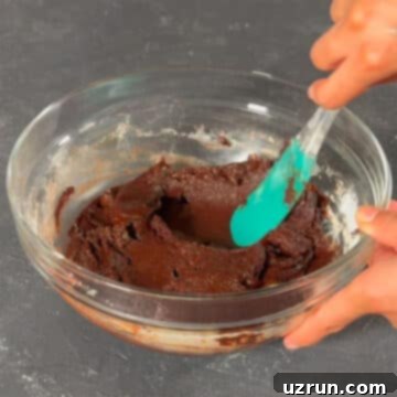 Easy Fudgy Oreo Brownies 8 Batter in glass bowl being mixed with a spatula, just until combined.