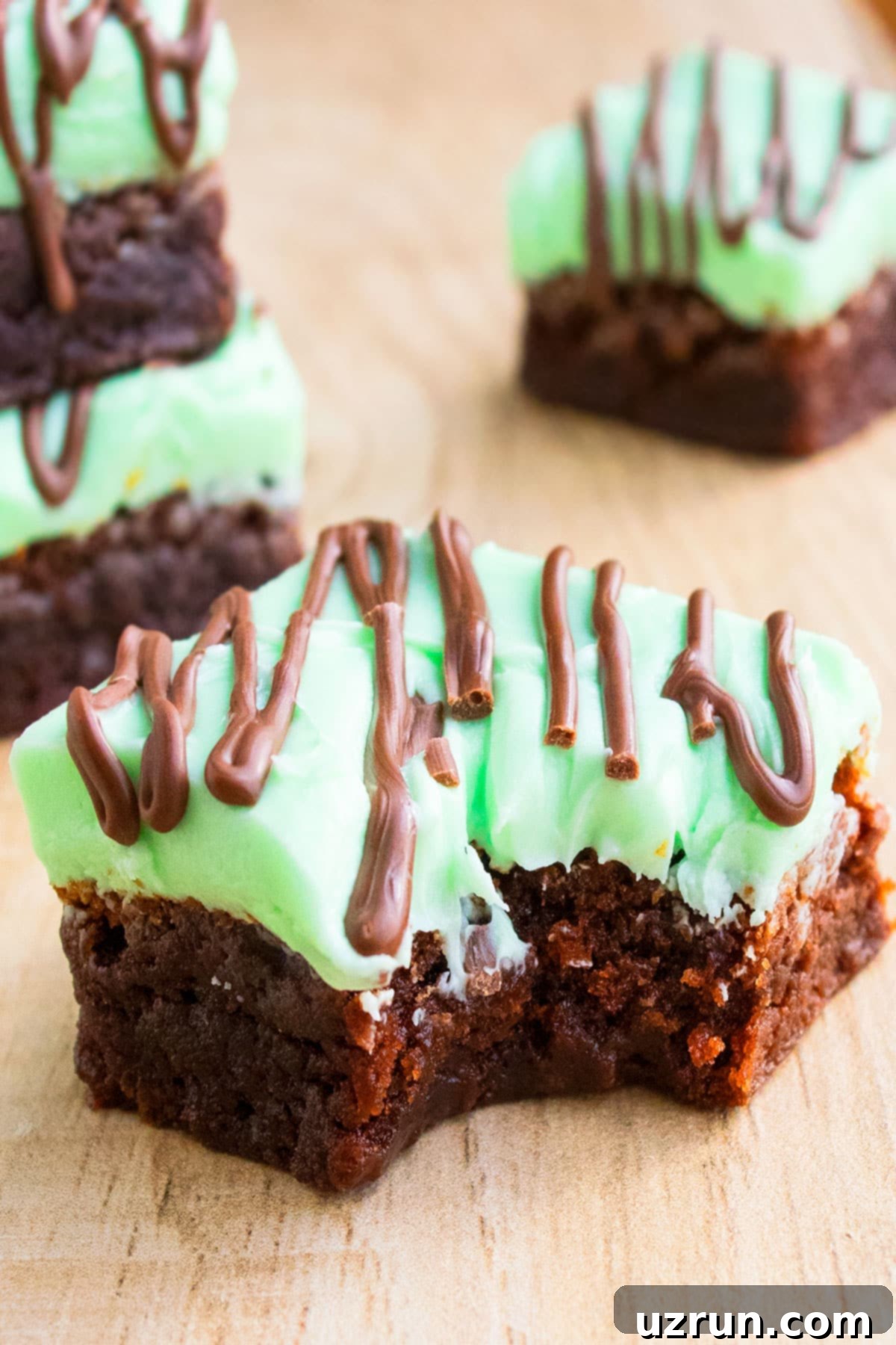 Fudgy Chocolate Mint Brownies 5 Partially Eaten Brownie Slice on Wood Background.