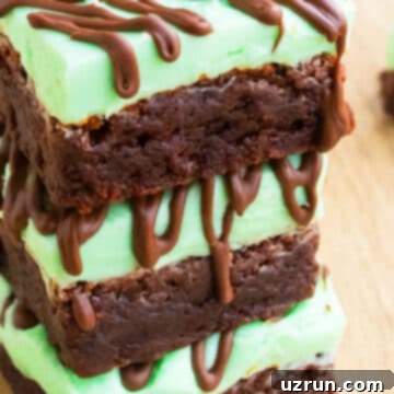 Fudgy Chocolate Mint Brownies 6 Stack of Chocolate Mint Brownies With Mint Buttercream Frosting on Wood Background.