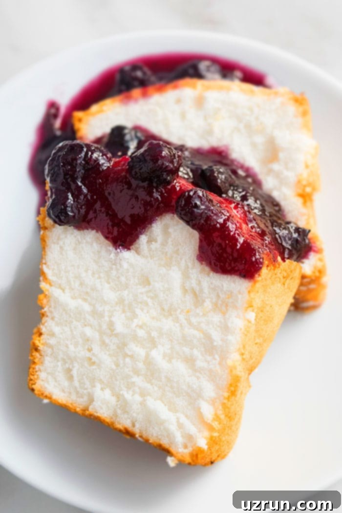 Slices of Angel Food Cake With Berry Toppings on White Dish. A light and airy cake perfect for summer.