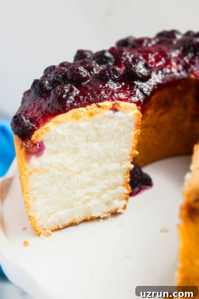 Fluffy Homemade Angel Food Cake 4 Closeup Shot of Angel Food Cake on White Dish, showcasing its light and delicate texture.