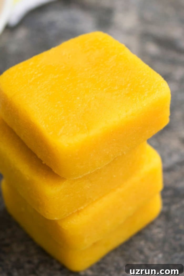 Simple Two-Ingredient Lemon Fudge 4 Stack of Creamy Fudge on Rustic Gray Background.