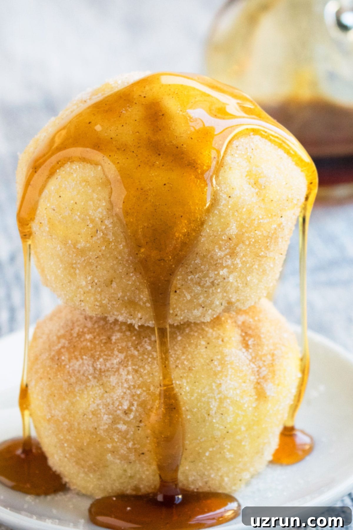 Soft and Moist Cinnamon Muffins 5 Maple Syrup Dripping on Stack of Muffins on White Dish.