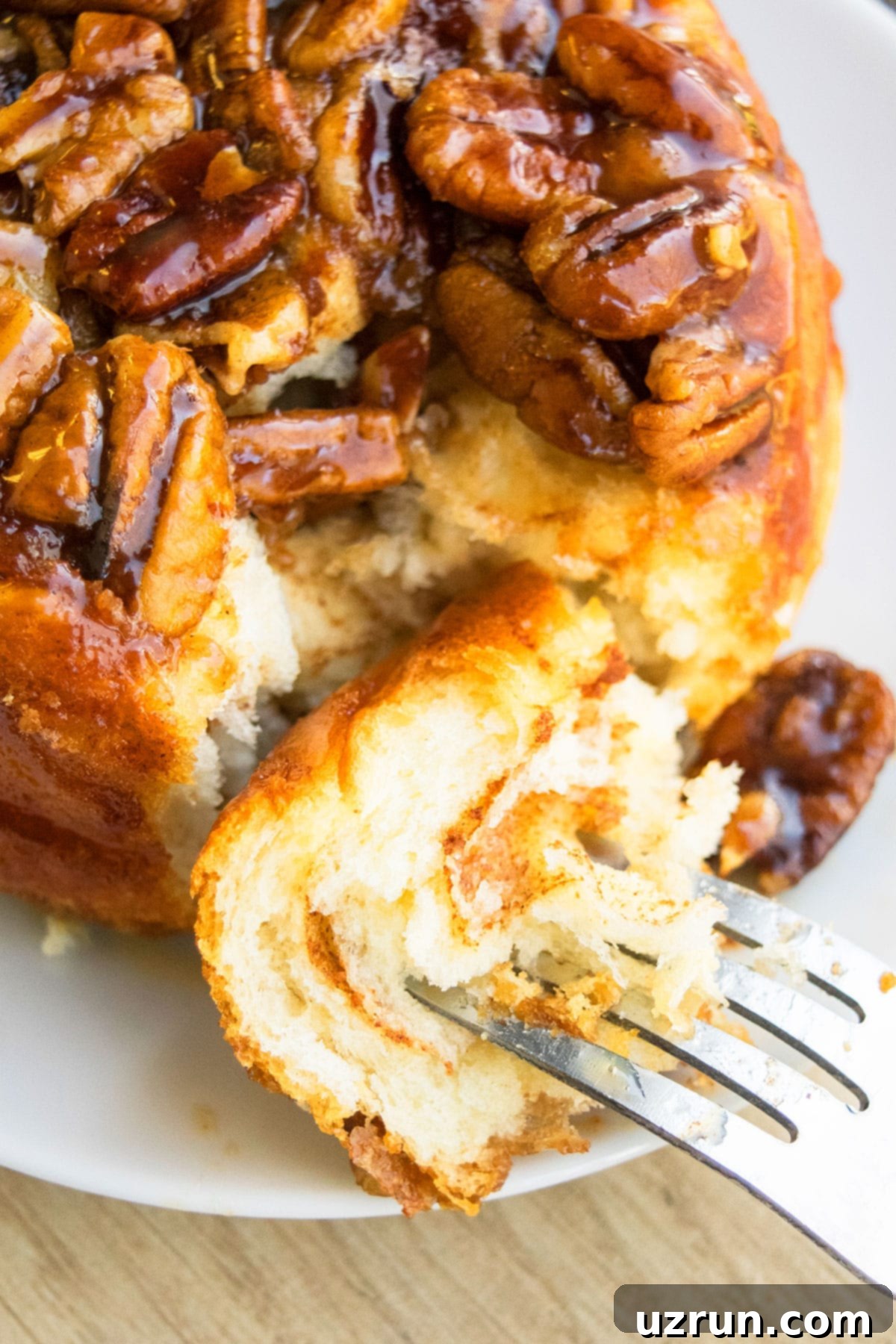 Pecan Caramel Sticky Buns 4 Fork Full of Homemade Sweet Buns on White Dish- Closeup Shot.