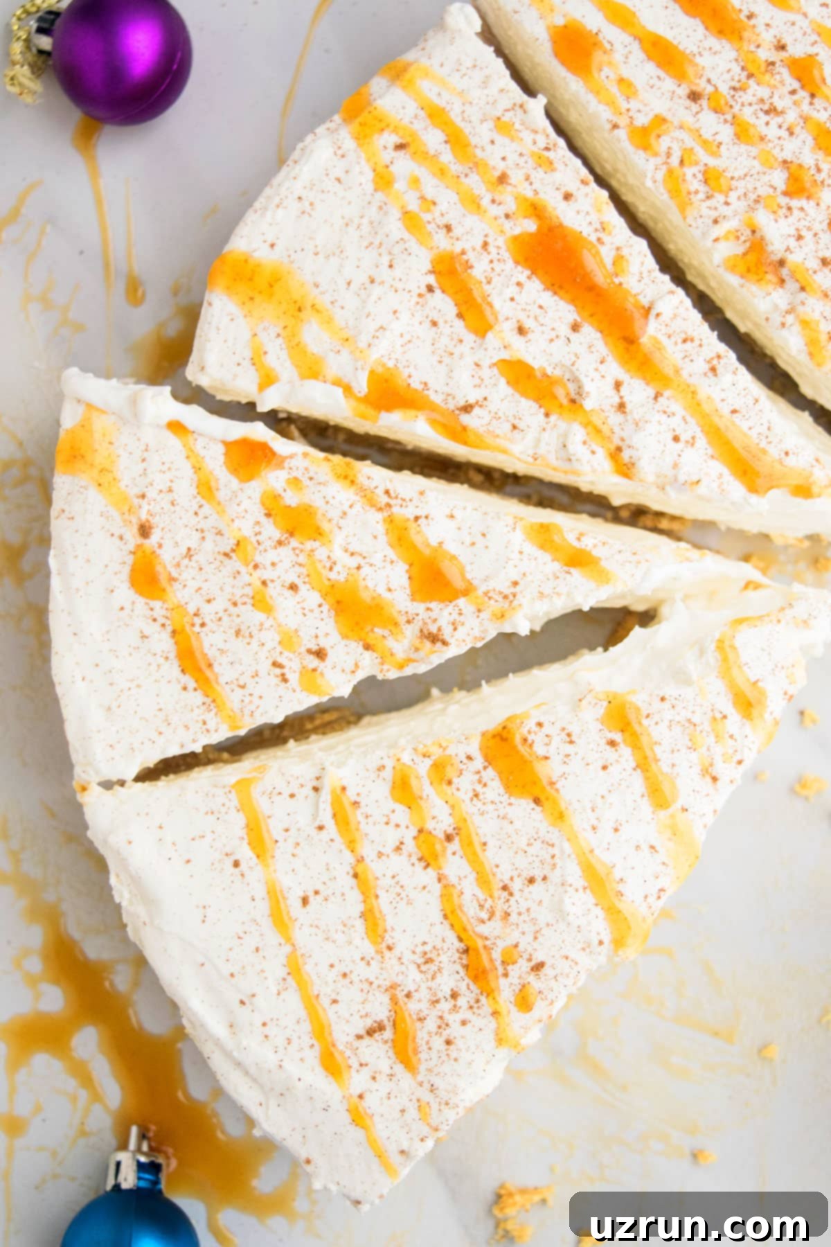No-Bake Eggnog Cheesecake 4 Several slices of luxurious No Bake Eggnog Cheesecake, each generously drizzled with rich caramel sauce and garnished with a sprinkle of nutmeg, presented on a white table.